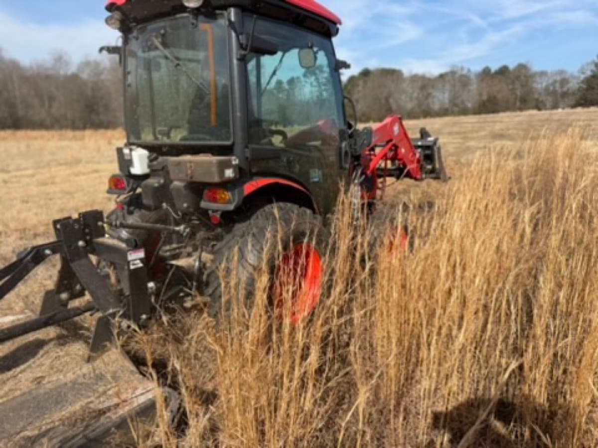 Brush hogging with tractor and Ironcraft bush hog near a pond in Easley SC